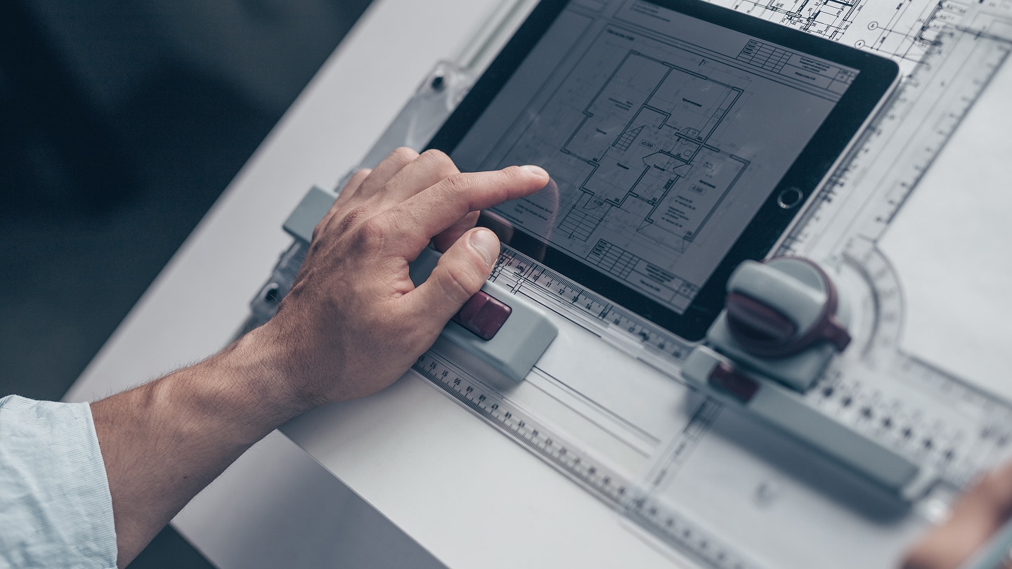 Bauprojektplanung auf einem Tablet mit digitalem Gebäudegrundriss